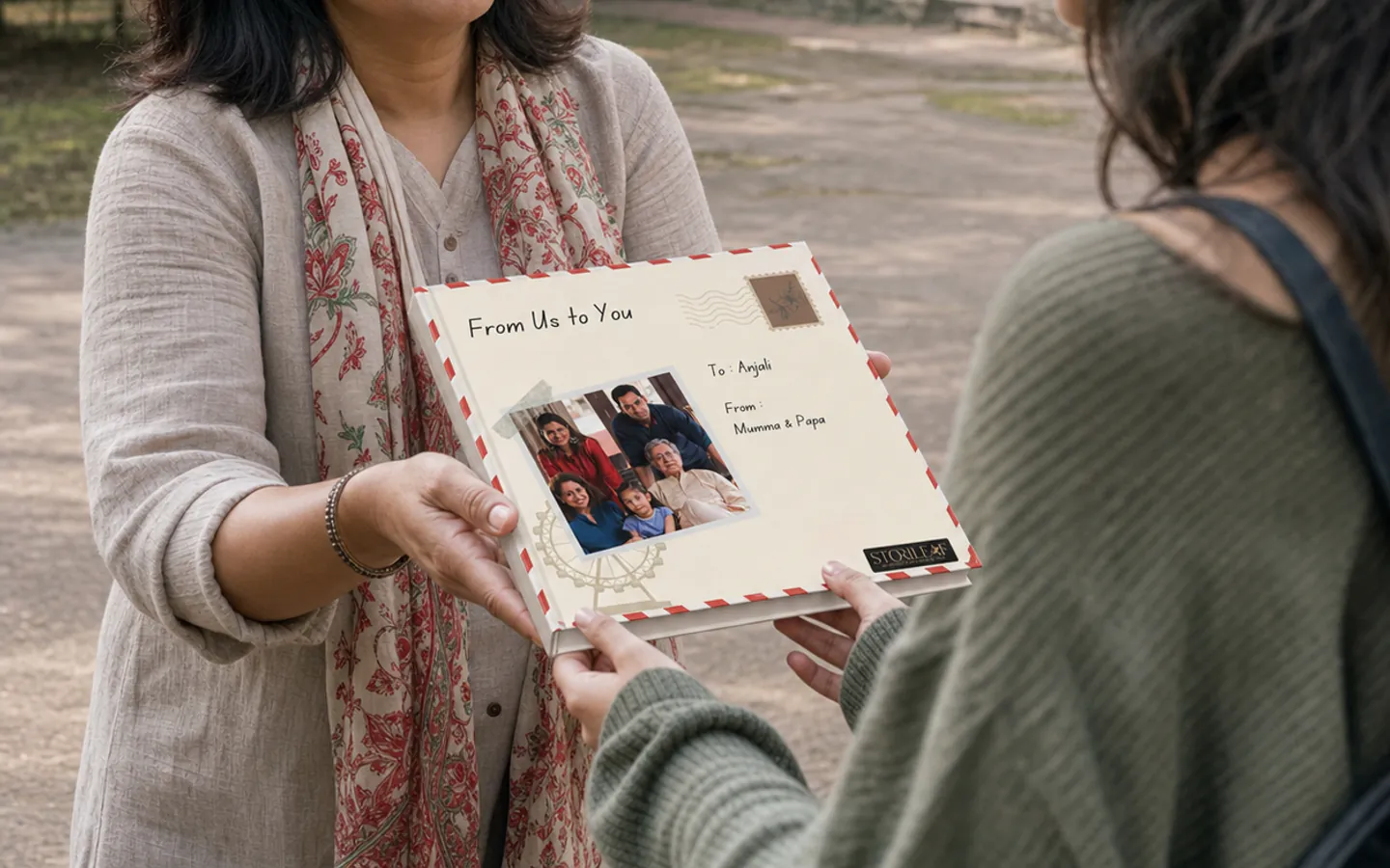 A north-east Indian mother giving a square Parent to Child Letters book to her adult daughter
