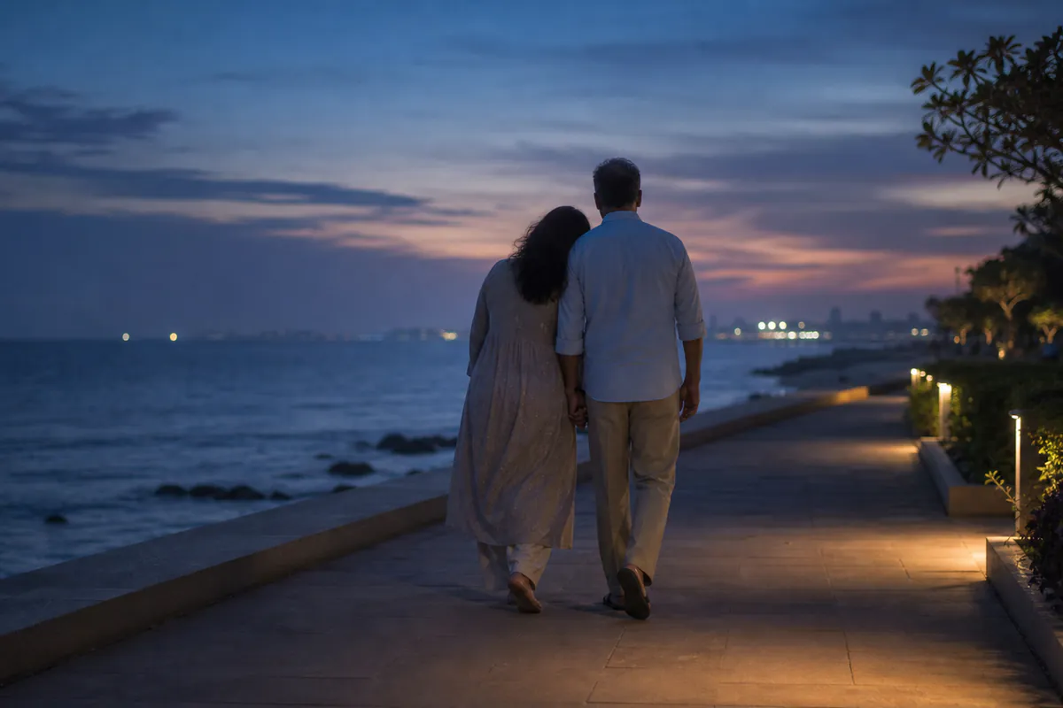 A mature Indian couple walking closely together beside the sea